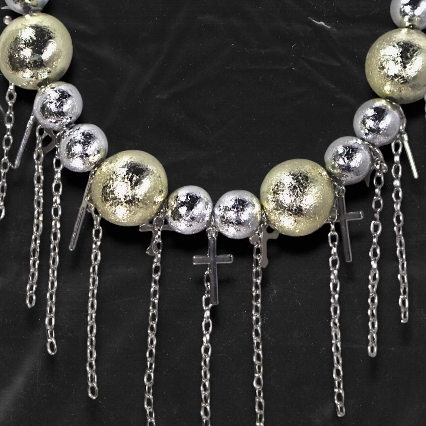 Chockychoker “ Mirror Pop ” is a Bold disco-inspired choker featuring large gold and silver reflective beads with a crackled-glass texture, silver-tone alloy cross pendants, and cascading metal chain tassels. This statement necklace merges glam and industrial aesthetics, ideal for lovers of disco, cyberpunk, rave, glam goth, and edgy Y2K fashion.