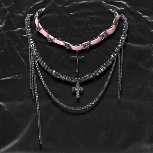 Chockychoker “Angel Trap” is a handcrafted dual-layer choker combining a braided pink faux leather strap interwoven with black-silver alloy components on the top layer, accented by a silver metal cross pendant. The lower layer features chunky metal beads with embossed, textured surfaces and a silver-tone cross charm embedded with light pink crystal-like stones. Multiple dangling silver chains add dimension and movement. This statement accessory making it ideal for Y2K, cyber-goth, punk,  and  rich materials