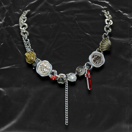 Chockychoker "Dear Item" choker is a silver-based statement piece accented in red, gold, white, and green. It features seal-like silver and gold medallions, a red cross, a green heart charm, faux pearls, vintage-style metallic buttons, a long silver dangling chain, and shell-inspired pieces. Like a wearable collection of curious treasures, this piece blends fantasy, vintage, and Y2K styles—perfect for fairycore, eclectic, and narrative-driven fashion lovers.

