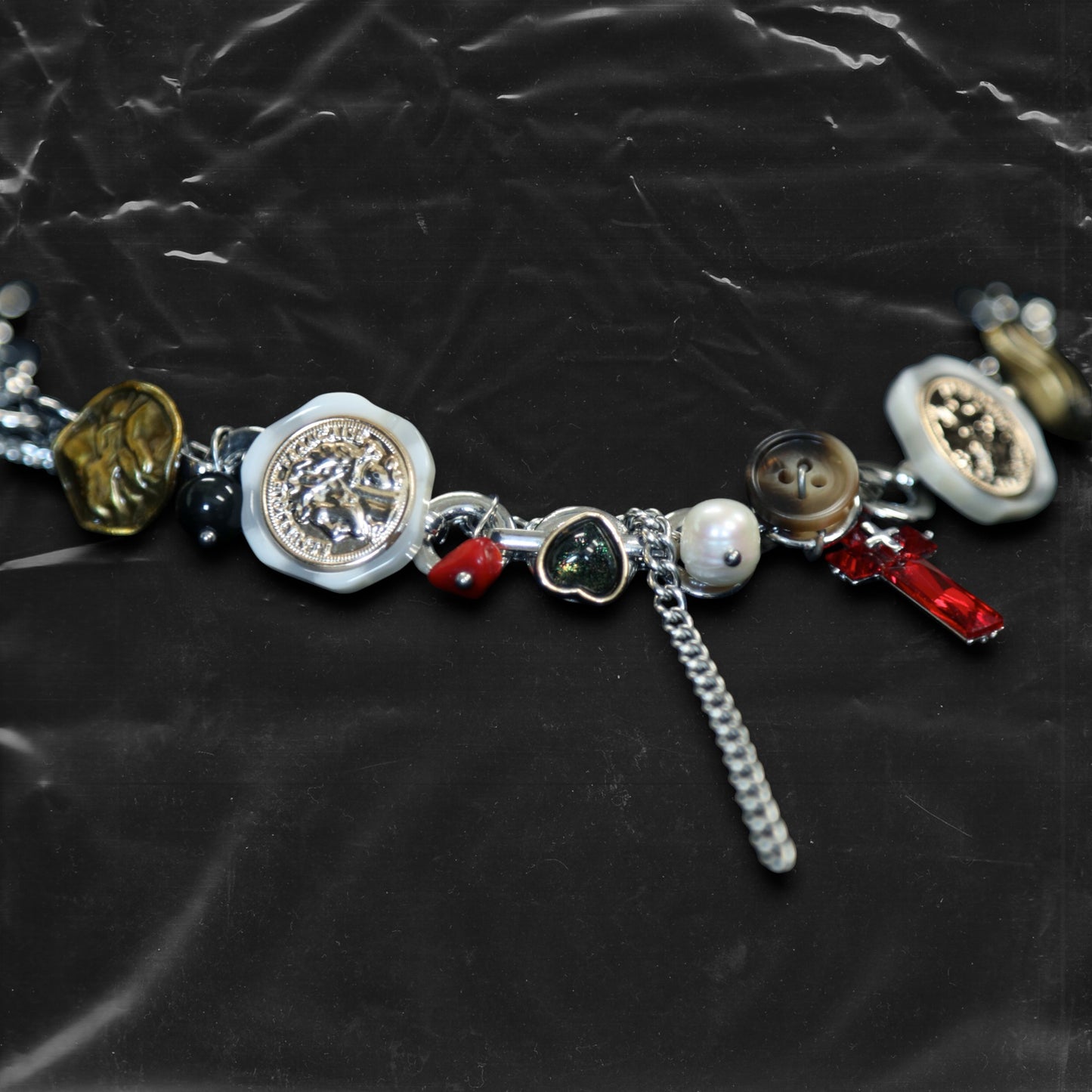 Chockychoker "Dear Item" choker is a silver-based statement piece accented in red, gold, white, and green. It features seal-like silver and gold medallions, a red cross, a green heart charm, faux pearls, vintage-style metallic buttons, a long silver dangling chain, and shell-inspired pieces. Like a wearable collection of curious treasures, this piece blends fantasy, vintage, and Y2K styles—perfect for fairycore, eclectic, and narrative-driven fashion lovers.

