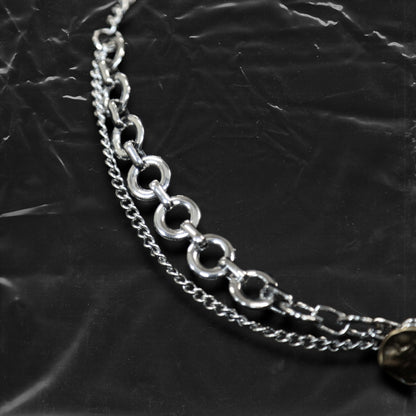 Chockychoker "Dear Item" choker is a silver-based statement piece accented in red, gold, white, and green. It features seal-like silver and gold medallions, a red cross, a green heart charm, faux pearls, vintage-style metallic buttons, a long silver dangling chain, and shell-inspired pieces. Like a wearable collection of curious treasures, this piece blends fantasy, vintage, and Y2K styles—perfect for fairycore, eclectic, and narrative-driven fashion lovers.

