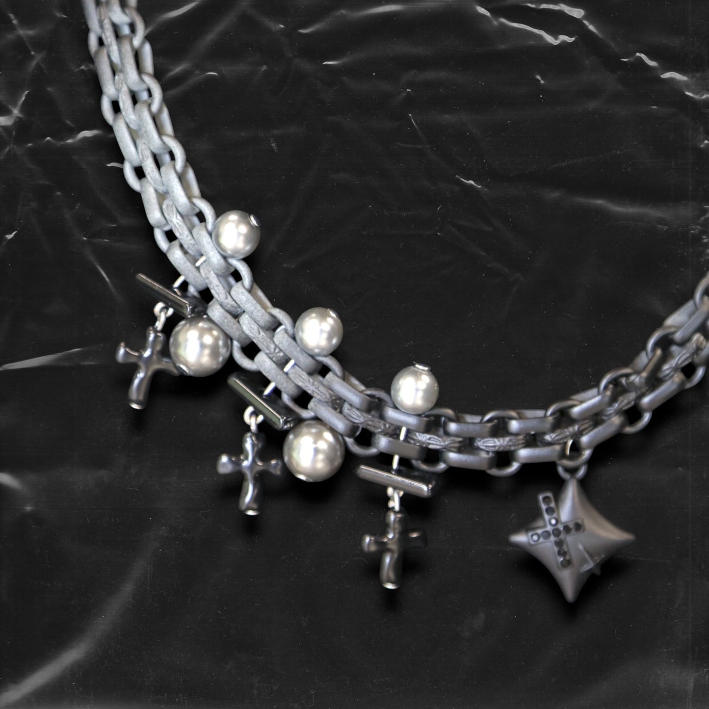 Chockychoker "Echo Unit" is a gradient silver chain choker featuring industrial-style links combined with metallic pearl beads. Multiple silver and black cross charms dangle along the chain, centered by a sculpted three-dimensional star pendant inlaid with black crystals. The overall design blends gothic, Y2K, industrial, and punk aesthetics, perfect for those drawn to dark, bold, and empowering styles.