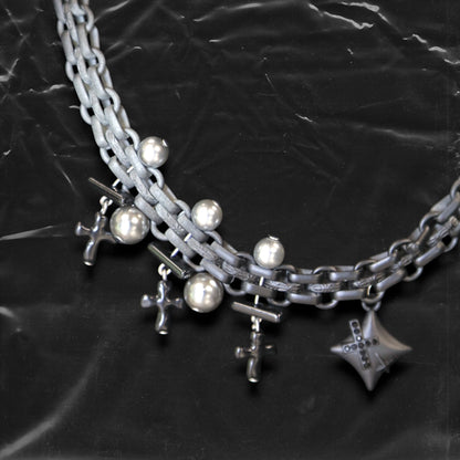 Chockychoker "Echo Unit" is a gradient silver chain choker featuring industrial-style links combined with metallic pearl beads. Multiple silver and black cross charms dangle along the chain, centered by a sculpted three-dimensional star pendant inlaid with black crystals. The overall design blends gothic, Y2K, industrial, and punk aesthetics, perfect for those drawn to dark, bold, and empowering styles.