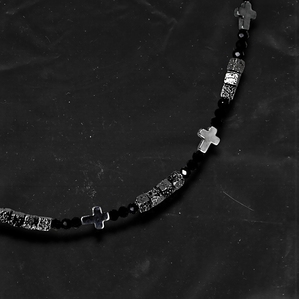 Chockychoker "Grain Script" Necklace
This necklace features a fine silver chain adorned with matte black square beads, textured metal cube spacers, and minimalist silver cross pendants. With clean lines and a cool-toned palette, it fuses gothic and dark Y2K aesthetics in a restrained yet strikingly expressive style. Perfect for lovers of dark minimalism and layered statement accessories.

