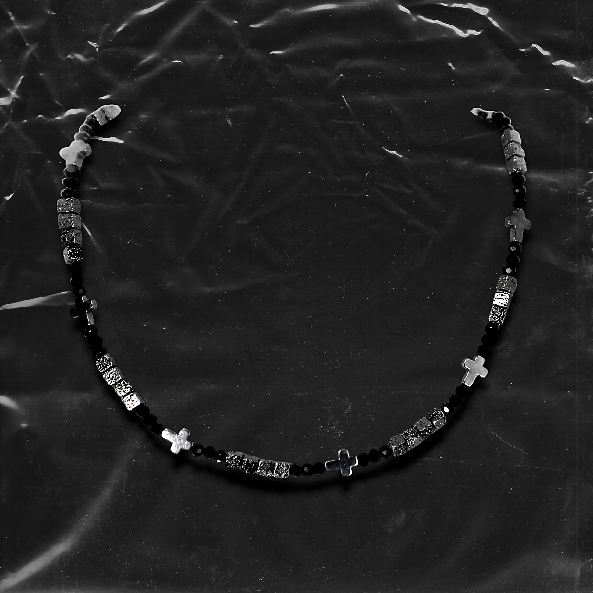 Chockychoker "Grain Script" Necklace
This necklace features a fine silver chain adorned with matte black square beads, textured metal cube spacers, and minimalist silver cross pendants. With clean lines and a cool-toned palette, it fuses gothic and dark Y2K aesthetics in a restrained yet strikingly expressive style. Perfect for lovers of dark minimalism and layered statement accessories.

