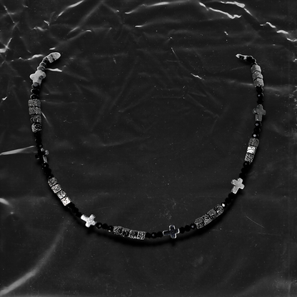 Chockychoker "Grain Script" Necklace
This necklace features a fine silver chain adorned with matte black square beads, textured metal cube spacers, and minimalist silver cross pendants. With clean lines and a cool-toned palette, it fuses gothic and dark Y2K aesthetics in a restrained yet strikingly expressive style. Perfect for lovers of dark minimalism and layered statement accessories.

