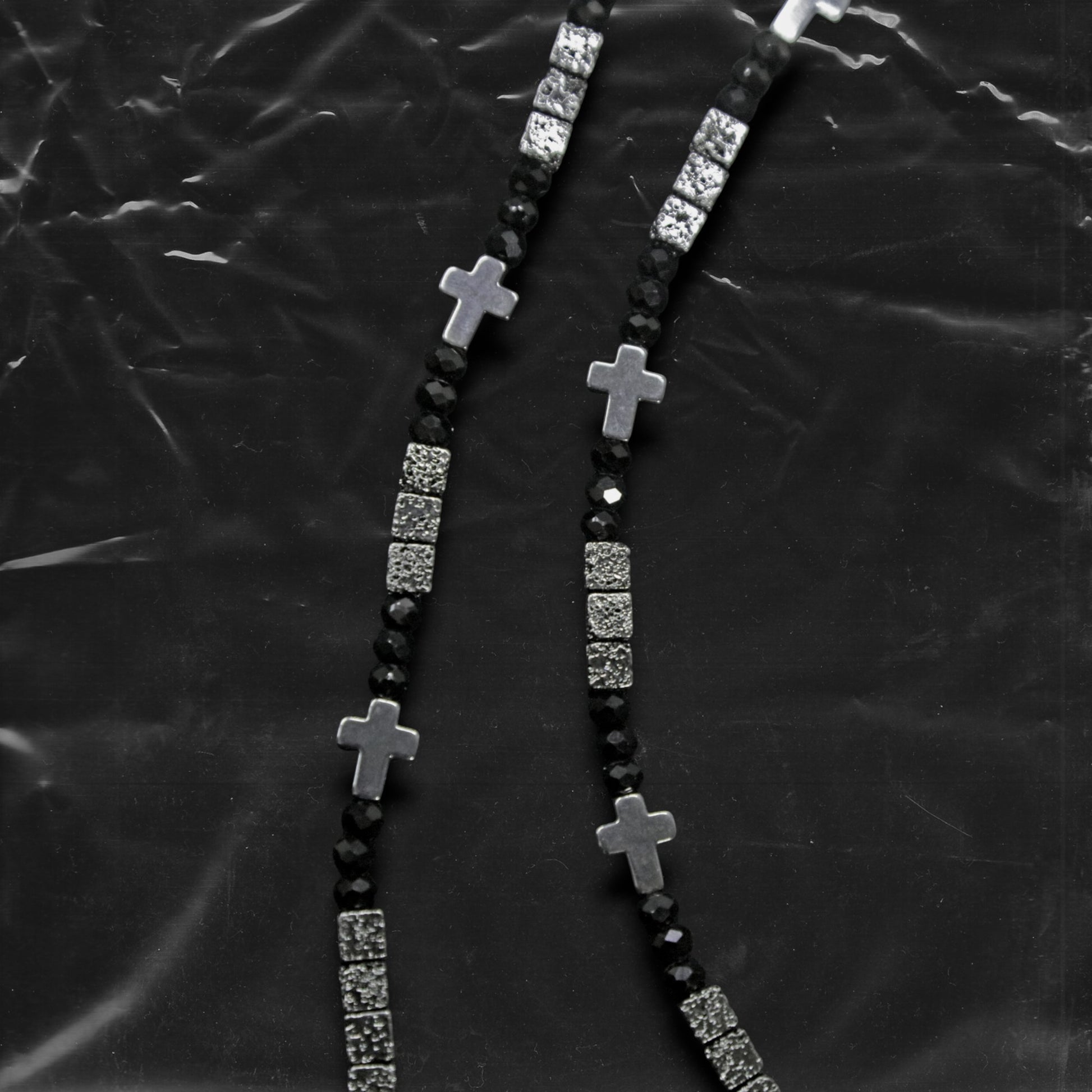 Chockychoker "Grain Script" Necklace
This necklace features a fine silver chain adorned with matte black square beads, textured metal cube spacers, and minimalist silver cross pendants. With clean lines and a cool-toned palette, it fuses gothic and dark Y2K aesthetics in a restrained yet strikingly expressive style. Perfect for lovers of dark minimalism and layered statement accessories.

