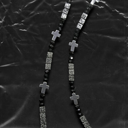 Chockychoker "Grain Script" Necklace
This necklace features a fine silver chain adorned with matte black square beads, textured metal cube spacers, and minimalist silver cross pendants. With clean lines and a cool-toned palette, it fuses gothic and dark Y2K aesthetics in a restrained yet strikingly expressive style. Perfect for lovers of dark minimalism and layered statement accessories.

