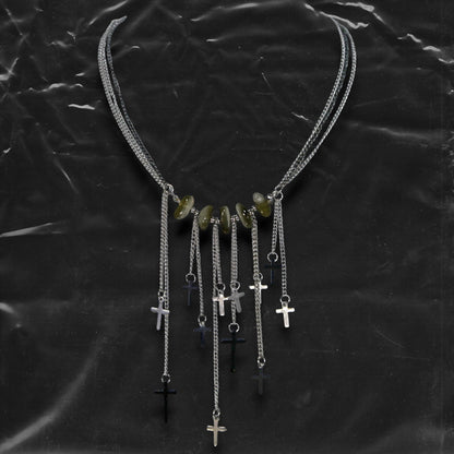 Chockychoker “Graviton Choir” Necklace is crafted from layered silver-toned fine chains, creating a fluid, multi-dimensional silhouette. The center is accented with amber glass beads, Along the lower edge, silver cross pendants are arranged in a staggered pattern. Blending gothic mystique and religious symbolism with Y2K futurism and industrial-punk edge, this piece is perfect for those drawn to dark romanticism, layered accessories, and strong visual presence in styling.
