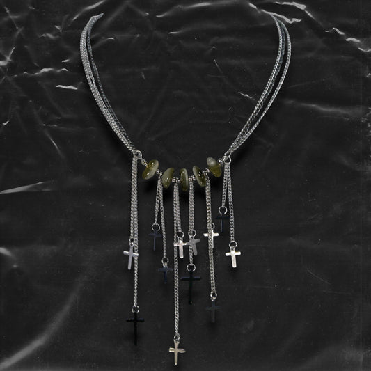 Chockychoker “Graviton Choir” Necklace is crafted from layered silver-toned fine chains, creating a fluid, multi-dimensional silhouette. The center is accented with amber glass beads, Along the lower edge, silver cross pendants are arranged in a staggered pattern. Blending gothic mystique and religious symbolism with Y2K futurism and industrial-punk edge, this piece is perfect for those drawn to dark romanticism, layered accessories, and strong visual presence in styling.
