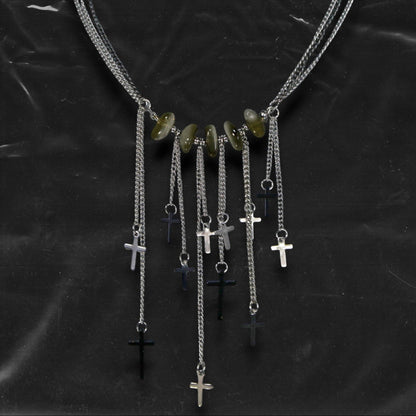 Chockychoker “Graviton Choir” Necklace is crafted from layered silver-toned fine chains, creating a fluid, multi-dimensional silhouette. The center is accented with amber glass beads, Along the lower edge, silver cross pendants are arranged in a staggered pattern. Blending gothic mystique and religious symbolism with Y2K futurism and industrial-punk edge, this piece is perfect for those drawn to dark romanticism, layered accessories, and strong visual presence in styling.
