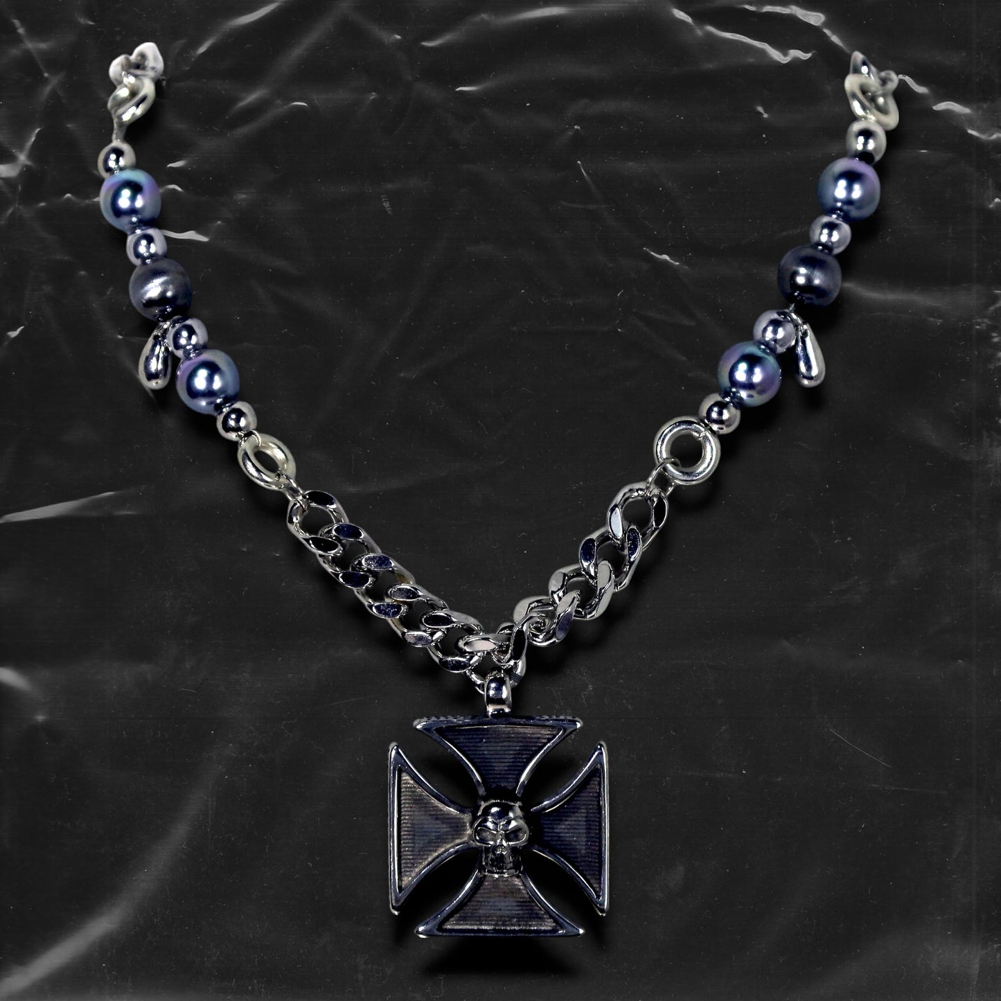 Chockychoker "Knightmare" choker is inspired by the dark knight aesthetic. At its center hangs a black skull-embossed cross pendant, flanked by deep silver and navy-toned metallic pearls intertwined with bold silver chains. The piece embodies a sense of strength and cold elegance, fusing gothic, punk, and Y2K elements. Ideal for those drawn to dark fashion, knightcore fantasy, and layered metallic statement accessories.