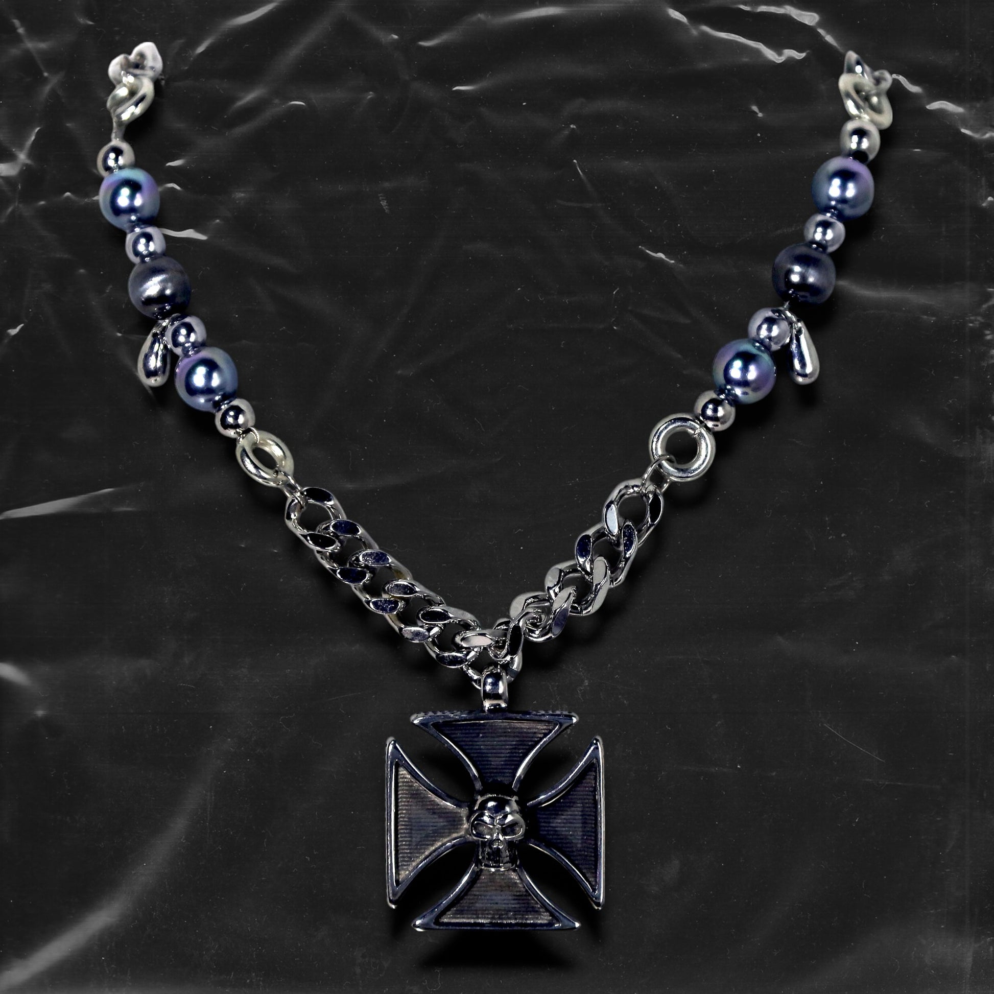 Chockychoker "Knightmare" choker is inspired by the dark knight aesthetic. At its center hangs a black skull-embossed cross pendant, flanked by deep silver and navy-toned metallic pearls intertwined with bold silver chains. The piece embodies a sense of strength and cold elegance, fusing gothic, punk, and Y2K elements. Ideal for those drawn to dark fashion, knightcore fantasy, and layered metallic statement accessories.