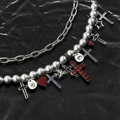 Chockychoker “ Metal Creed ” is a Double-layer choker necklace featuring metallic silver beads and a chunky alloy chain, adorned with a central cross pendant inlaid with sparkling red crystals. Additional charms include alloy cross pendants,  red heart, crescent moon, and hollow star. This statement choker is ideal for gothic, punk, glam-rock, Y2K, and edgy alternative fashion styles.
