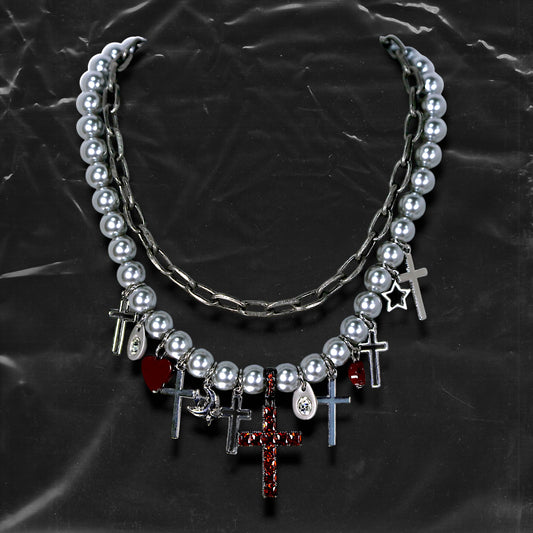 Chockychoker “ Metal Creed ” is a Double-layer choker necklace featuring metallic silver beads and a chunky alloy chain, adorned with a central cross pendant inlaid with sparkling red crystals. Additional charms include alloy cross pendants,  red heart, crescent moon, and hollow star. This statement choker is ideal for gothic, punk, glam-rock, Y2K, and edgy alternative fashion styles.
