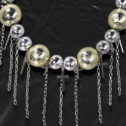 Chockychoker “ Mirror Pop ” is a Bold disco-inspired choker featuring large gold and silver reflective beads with a crackled-glass texture, silver-tone alloy cross pendants, and cascading metal chain tassels. This statement necklace merges glam and industrial aesthetics, ideal for lovers of disco, cyberpunk, rave, glam goth, and edgy Y2K fashion.
