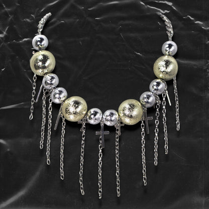 Chockychoker “ Mirror Pop ” is a Bold disco-inspired choker featuring large gold and silver reflective beads with a crackled-glass texture, silver-tone alloy cross pendants, and cascading metal chain tassels. This statement necklace merges glam and industrial aesthetics, ideal for lovers of disco, cyberpunk, rave, glam goth, and edgy Y2K fashion.

