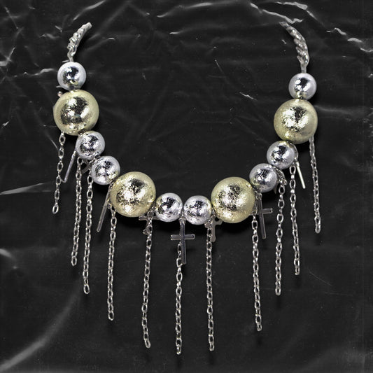 Chockychoker “ Mirror Pop ” is a Bold disco-inspired choker featuring large gold and silver reflective beads with a crackled-glass texture, silver-tone alloy cross pendants, and cascading metal chain tassels. This statement necklace merges glam and industrial aesthetics, ideal for lovers of disco, cyberpunk, rave, glam goth, and edgy Y2K fashion.
