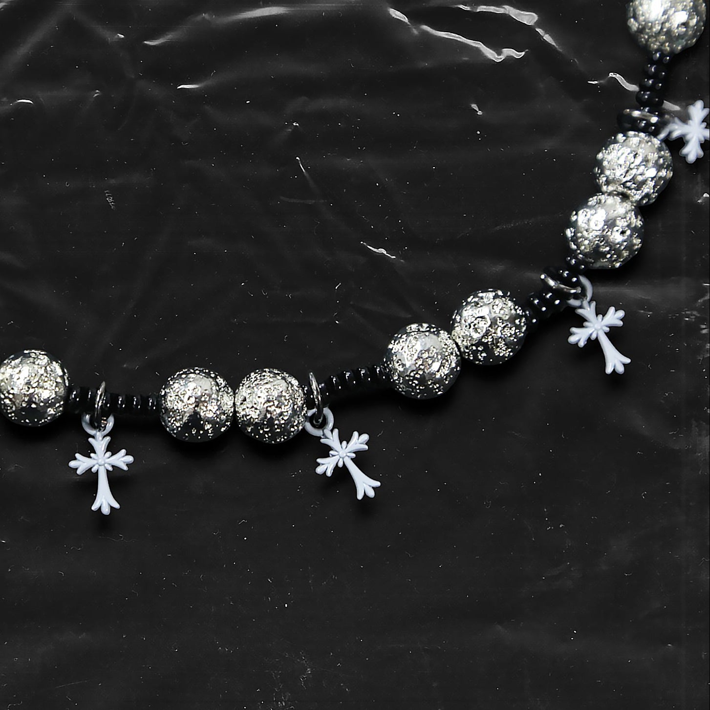 Chockychoker “Nova Chain I” is a Gothic choker necklace featuring white plastic cross charms and silver textured alloy beads, strung with black seed beads. Perfect for alternative, Y2K, punk, goth, and edgy fashion lovers. Statement unisex accessory with dark aesthetic and industrial vibe.
