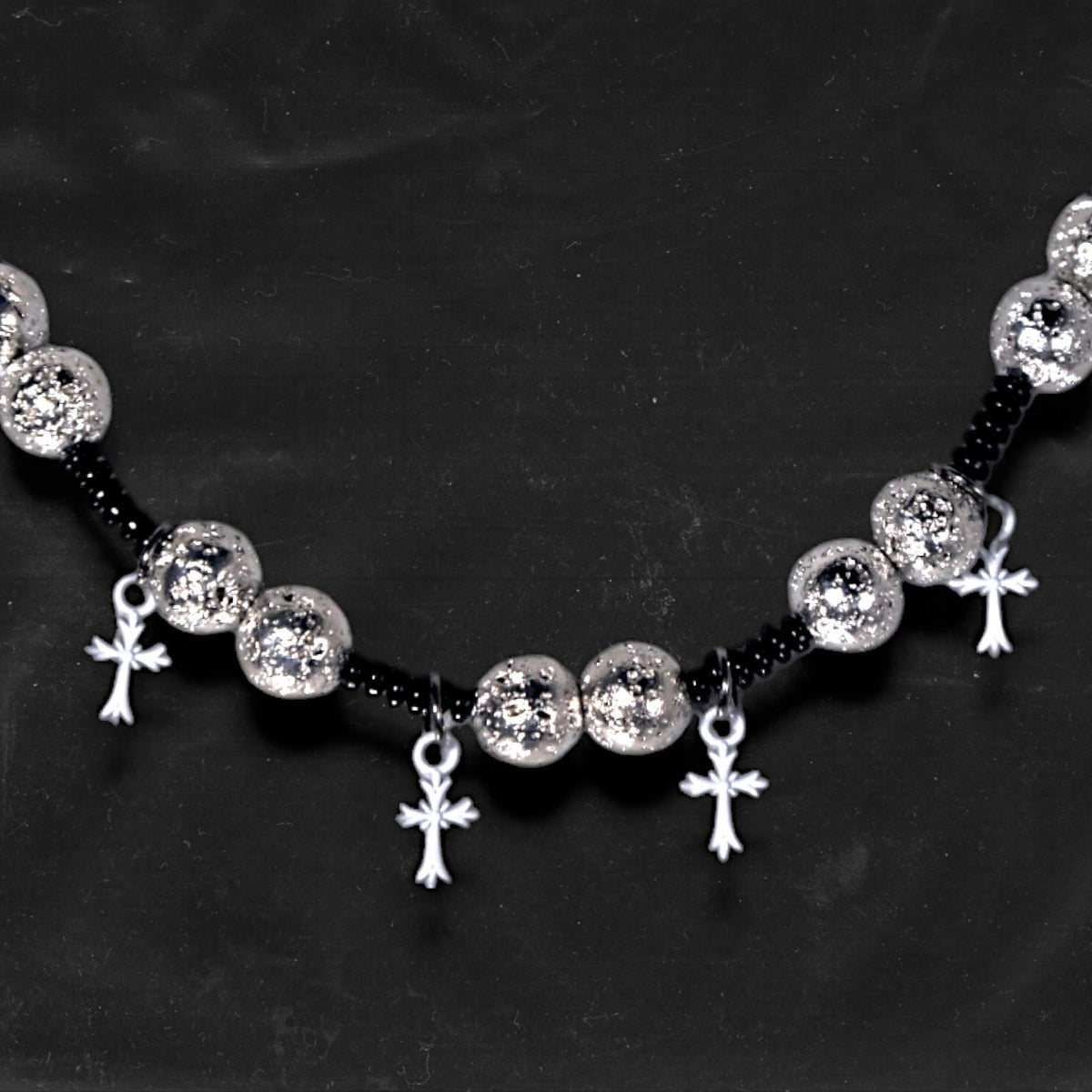 Chockychoker “Nova Chain I” is a Gothic choker necklace featuring white plastic cross charms and silver textured alloy beads, strung with black seed beads. Perfect for alternative, Y2K, punk, goth, and edgy fashion lovers. Statement unisex accessory with dark aesthetic and industrial vibe.
