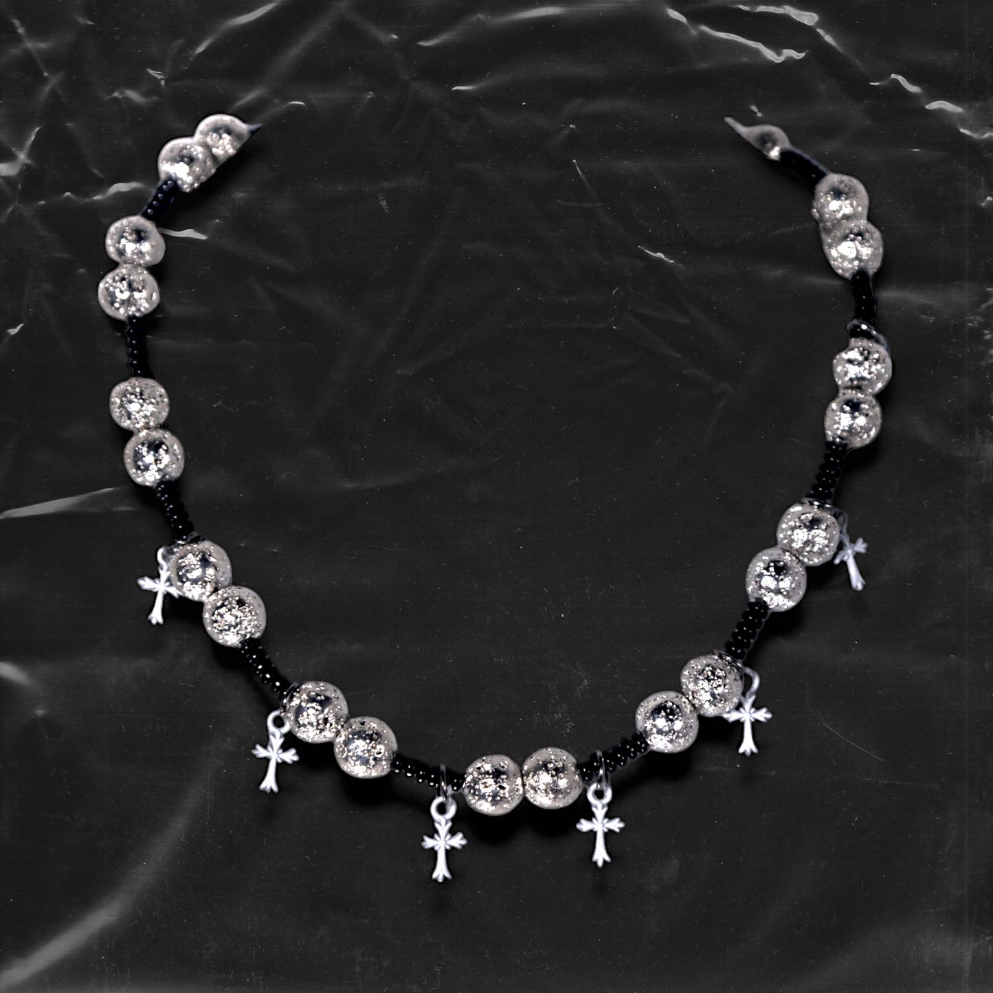 Chockychoker “Nova Chain I” is a Gothic choker necklace featuring white plastic cross charms and silver textured alloy beads, strung with black seed beads. Perfect for alternative, Y2K, punk, goth, and edgy fashion lovers. Statement unisex accessory with dark aesthetic and industrial vibe.
