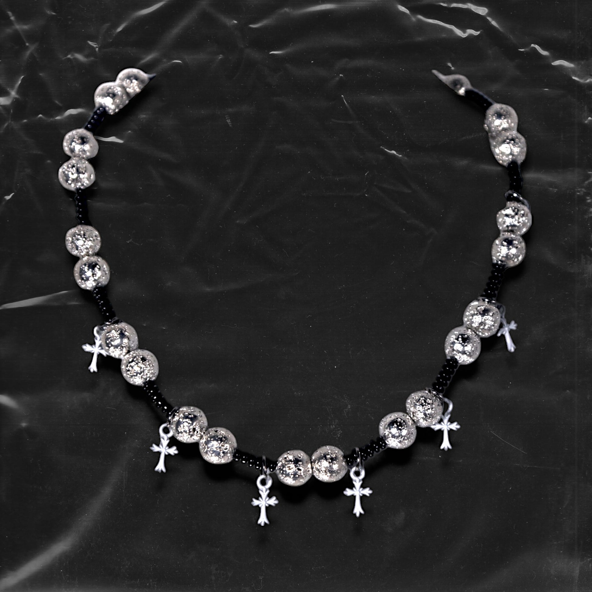 Chockychoker “Nova Chain I” is a Gothic choker necklace featuring white plastic cross charms and silver textured alloy beads, strung with black seed beads. Perfect for alternative, Y2K, punk, goth, and edgy fashion lovers. Statement unisex accessory with dark aesthetic and industrial vibe.
