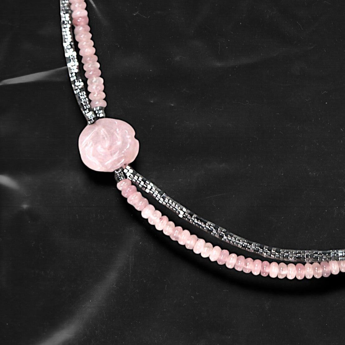 Chockychoker's “Rosé Whisper” is a handcrafted double-layer choker featuring soft pink rounded beads paired with faceted silver-tone glass beads. A delicately carved pale pink rose charm accents the left side, adding a touch of romantic flair. The color palette blends baby pink and silvery grey,  Perfect for styles like soft punk, balletcore, romantic Y2K, mellow tone , and Japanese commuter looks. Whether layered for a casual vibe or worn as a standout accessory for dressy or feminine outfits
