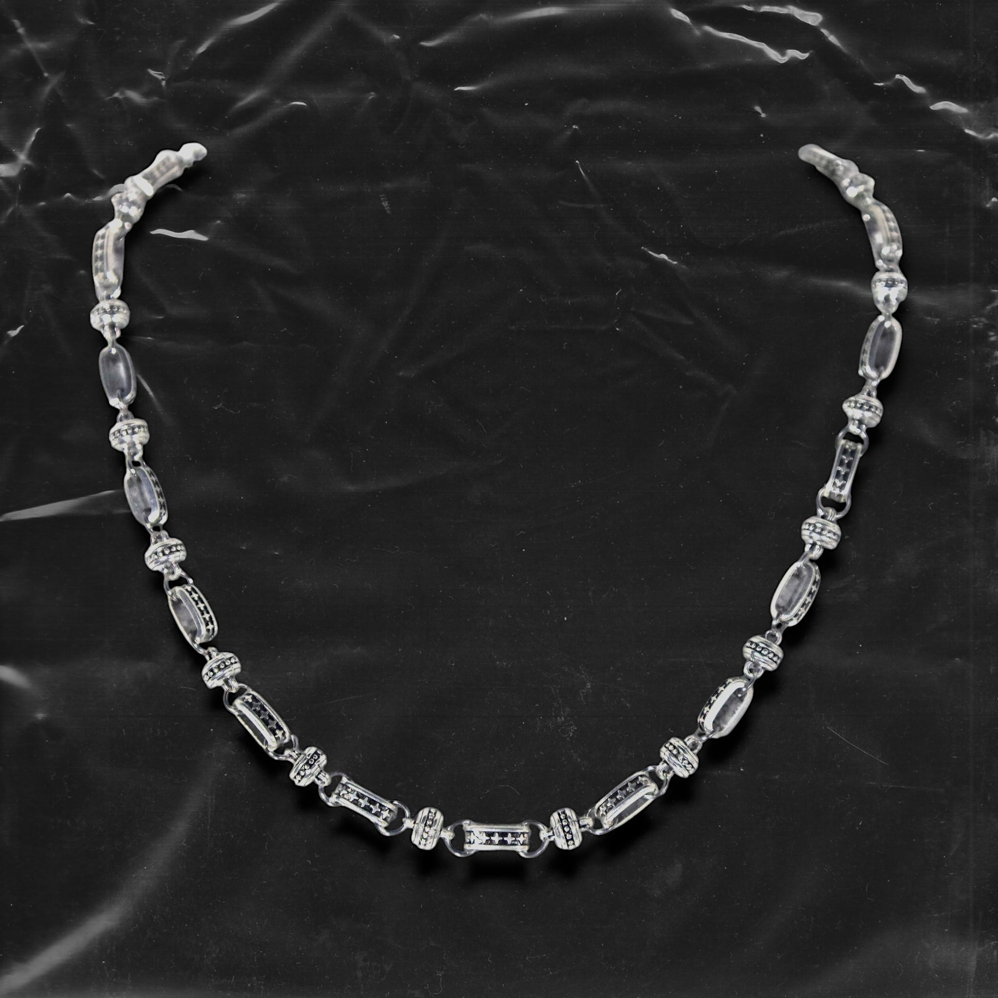 The Chockychoker “Stellar Orbit” necklace features alternating elliptical hollow beads and silver connectors engraved with star motifs, forming a celestial, orbital arrangement. The design exudes a strong sense of futurism and cosmic energy, perfect for styling in spacecore, Y2K, minimalist, and galaxy-inspired fashion aesthetics.
