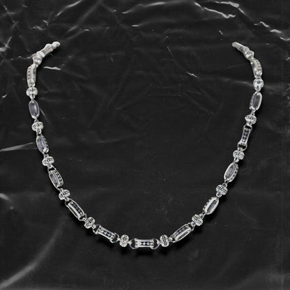 The Chockychoker “Stellar Orbit” necklace features alternating elliptical hollow beads and silver connectors engraved with star motifs, forming a celestial, orbital arrangement. The design exudes a strong sense of futurism and cosmic energy, perfect for styling in spacecore, Y2K, minimalist, and galaxy-inspired fashion aesthetics.
