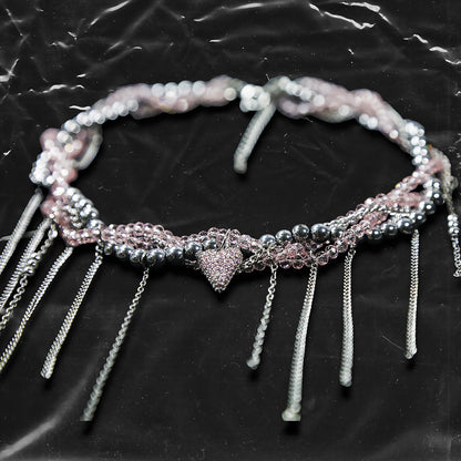 Chockychoker “ Sugarglow ” is a Double-layer twisted choker combining pink knit yarn and metallic silver alloy beads, adorned with a central heart-shaped charm inlaid with pink crystals. The necklace features dangling silver chains, transparent pink crystal drops, and a single star charm, evoking both sweetcore and edgy glam aesthetics. Perfect for lovers of Y2K revival, coquette fashion, Harajuku streetwear, Materials include silver-tone alloy, faux crystals, acrylic yarn, and metal chains.