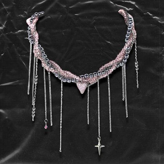 Chockychoker “ Sugarglow ” is a Double-layer twisted choker combining pink knit yarn and metallic silver alloy beads, adorned with a central heart-shaped charm inlaid with pink crystals. The necklace features dangling silver chains, transparent pink crystal drops, and a single star charm, evoking both sweetcore and edgy glam aesthetics. Perfect for lovers of Y2K revival, coquette fashion, Harajuku streetwear, Materials include silver-tone alloy, faux crystals, acrylic yarn, and metal chains.