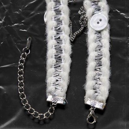 Chockychoker “Milk Galaxy” is a Handcrafted gothic-style choker made from soft white yarn interwoven with shimmering silver thread, adorned with layered silver-tone chains, a central baroque-style silver cross pendant, a mix of glossy white plastic buttons and vintage-style metallic buttons, and white oval resin charms ideal for lovers of gothic, alt, punk, lolita, soft grunge, and romantic street fashion. Perfect for those seeking statement chokers with unique handcrafted details and mixed media textures.
