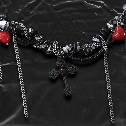 Chockychoker “Oath Object” is a gothic-inspired black ribbon choker featuring textured silver embellishments, dramatic silver-tone chain fringe, deep red heart charms, and a matte black cross pendant with floral details. Combining dark romance with edgy elements, this handcrafted piece blends punk, goth, emo, and Y2K aesthetics—perfect for those who love statement jewelry with emotional and symbolic undertones.
